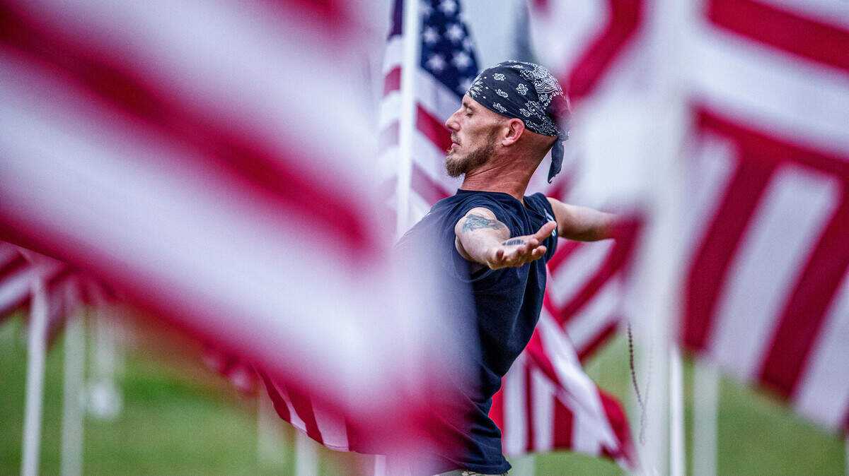 Shawn Thompson says a prayer amidst hundreds of American flags planted on a field just off U.S. Highway 377 in Granbury on Monday, May 31, 2021.