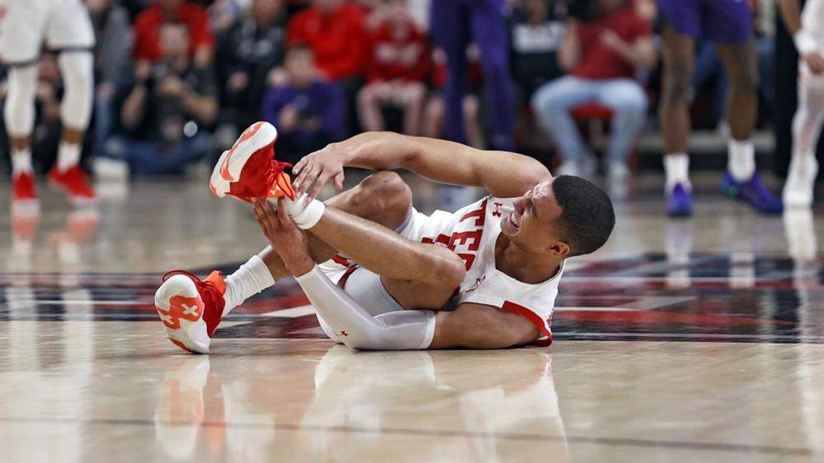 Texas Tech’s Kevin McCullar (15) grabs his ankle after falling to the floor during the first half of an NCAA college basketball game against TCU, Saturday, Feb. 12, 2022, in Lubbock, Texas. (AP Photo/Brad Tollefson)