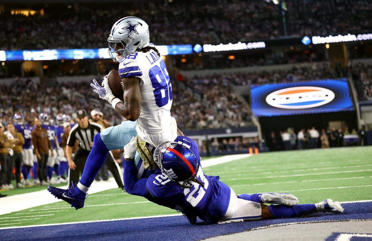 Dallas Cowboys wide receiver CeeDee Lamb pushes past New York Giants safety Bobby McCain to score a touchdown on Sunday, November 12, 2023, at AT&T Stadium in Arlington.