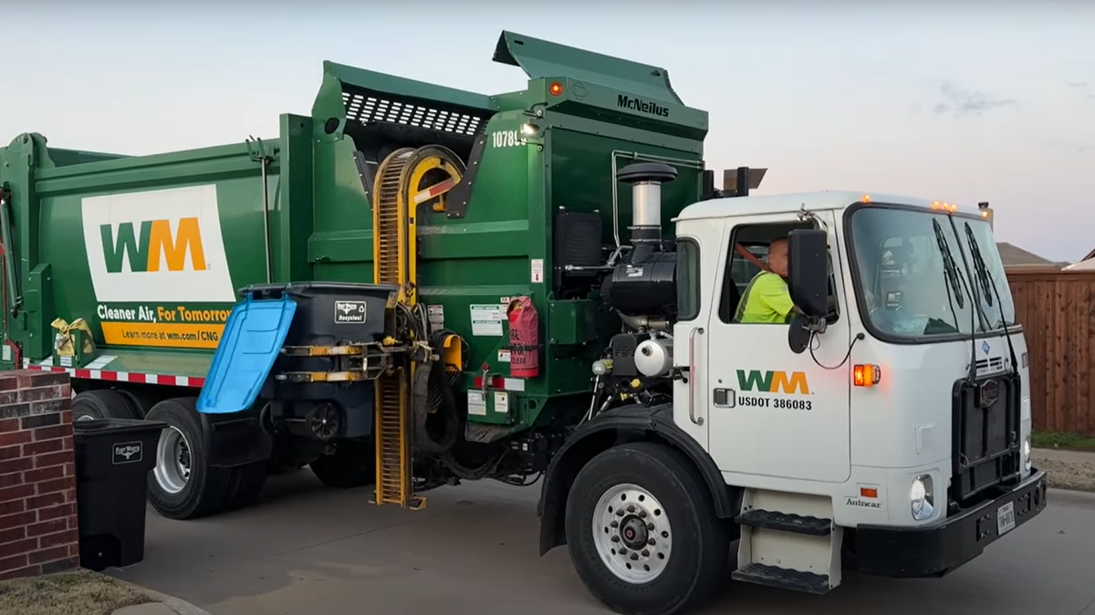 A WM collection truck makes its rounds in a Fort Worth neighborhood to collect recycling bin contents set out on curbside.