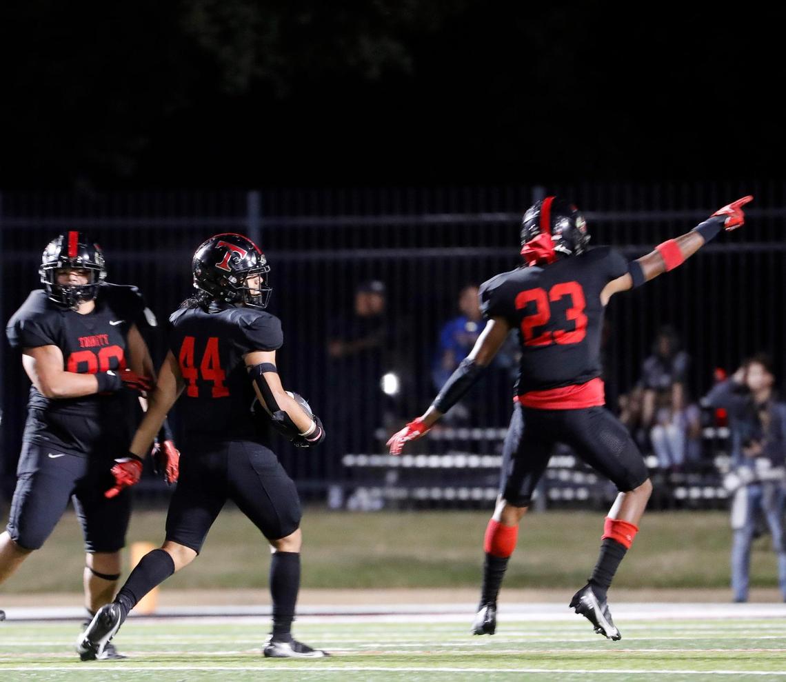 Trinity defensive back Devin Ugbaja (23) celebrates the fumble recovery by linebacker Momo Maumalanga (44) in the second half of a District 3-6A high school football game at Pennington Field in Bedford, Texas, Thursday, Nov. 03, 2022. Trinity defeated L.D. Bell 27-24 in overtime for the 25th year in a row. (Special to the Star-Telegram Bob Booth)