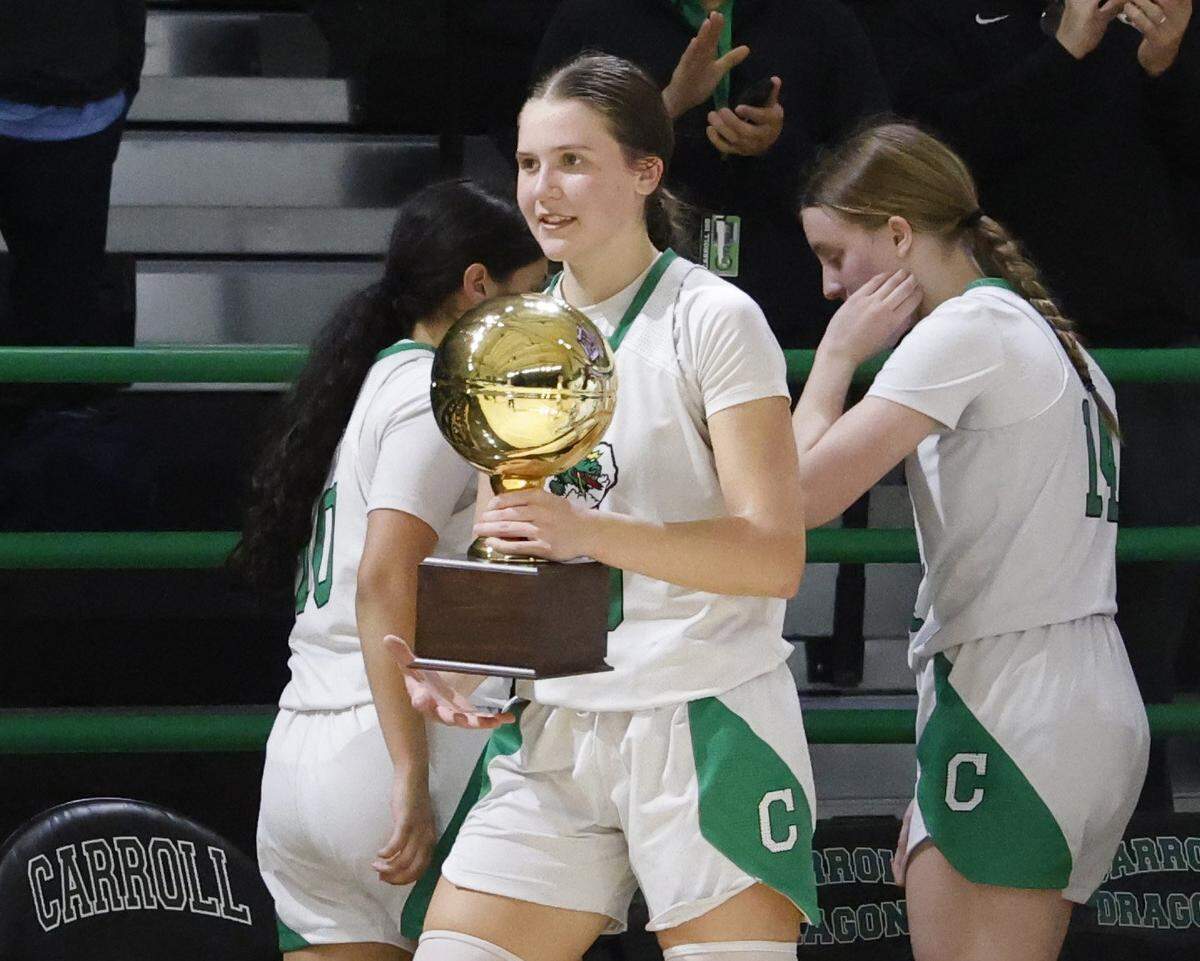 Southlake guard Whitney Jense (20) carries the trophy through the bench area after their UIL girls basketball game against L.D. Bell at Southlake Senior High School in Southlake, Texas, Tuesday Feb. 03, 2026