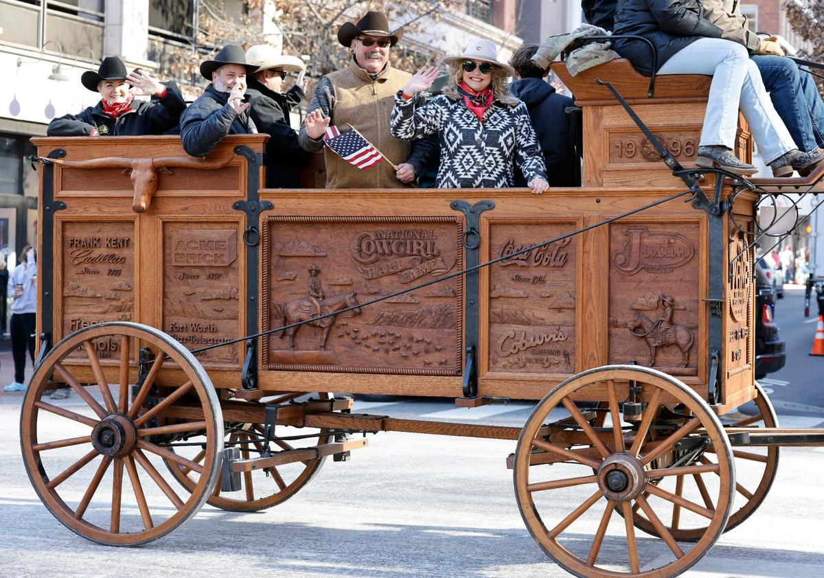 The carved wooden wagon of the Cowgirl Hall of Fame travels along Commerce Street.