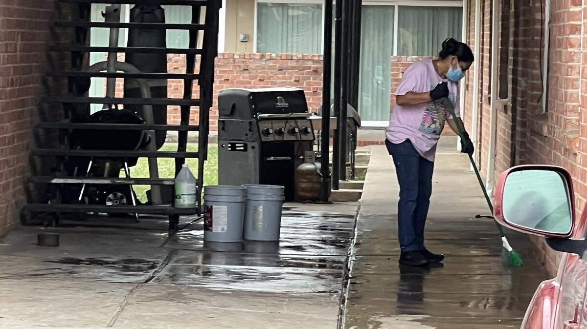 In connection with the June killing of a neighbor, police have booked into jail on suspicion of murder a resident of an east Fort Worth apartment building. A woman cleans the scene on June 22, 2023.
