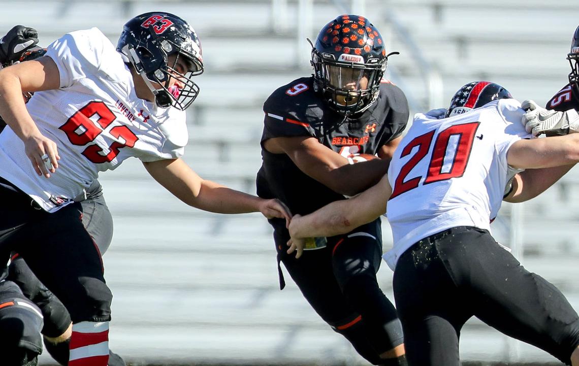 Aledo running back Jase McClellan (9) tries to get past Lovejoy linebacker Austin King (20) and lineman Sean Sumners (63) during the first half Friday in the 5A Division II Region II Area playoff game at Pennington Field in Bedford.