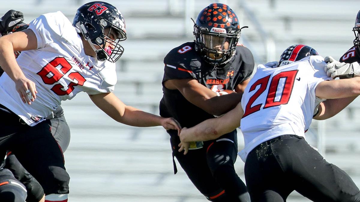 Aledo running back Jase McClellan (9) tries to get past Lovejoy linebacker Austin King (20) and lineman Sean Sumners (63) during the first half Friday in the 5A Division II Region II Area playoff game at Pennington Field in Bedford.