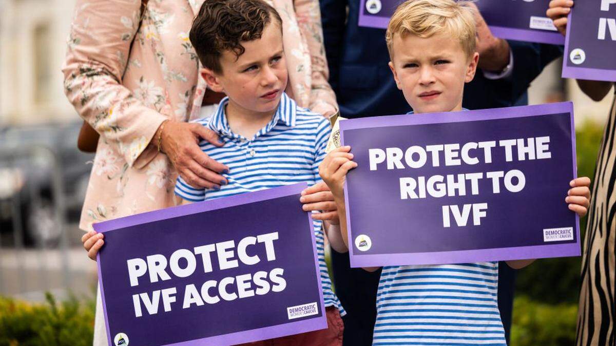 Liam Mullin (left) and Landon Mullin, the sons of Rep. Kevin Mullin. D-California, hold signs during a news conference in honor of World IVF Day to discuss the next steps for legislation to protect access to in vitro fertilization across America on July 25, 2024 in Washington, DC. 