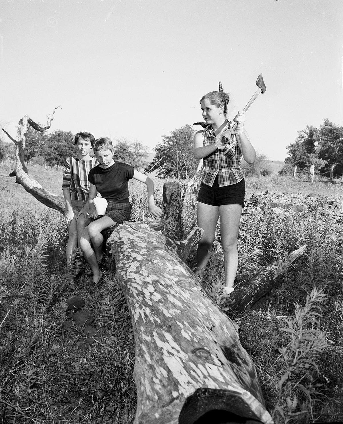 June 26, 1958: Joyce Wakefield, 15, wields an ax in preparation for a Girl Scout cookout. Later she and Jean Farmer, left, 16, and Beverly Wilson, 14, will gather with other campers around campfire.