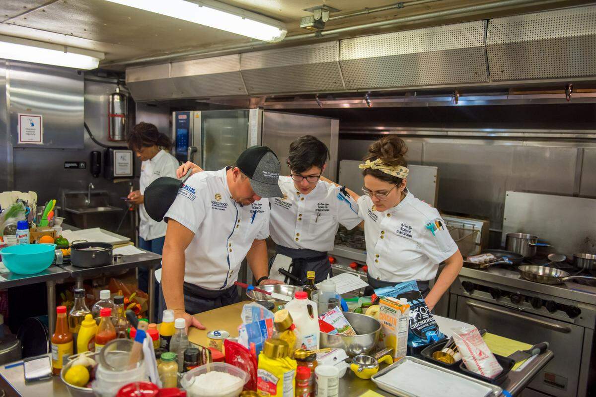 Peter, Preston and Emma Nguyen, gather together before they begin cooking at the World Food Championships “Final Table” in Columbia, South Carolina.