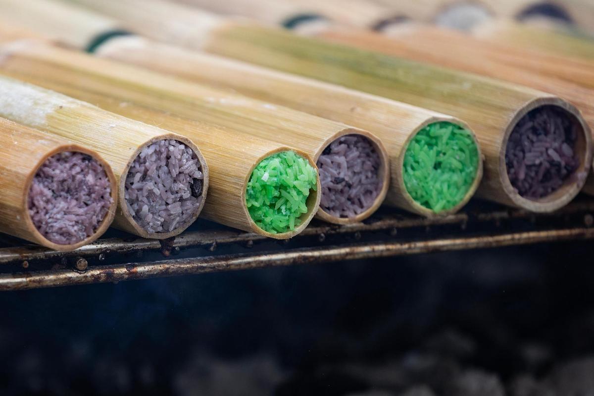Khao Lam is cooked on the grill on the third day of the Lao New Year festival at Wat Lao Thepnimith Temple in Saginaw on Sunday, April 27, 2025. Khao Lam is a popular Thai dessert consisting of sticky rice, sugar, and coconut milk, cooked in a hollow bamboo cylinder over an open fire.