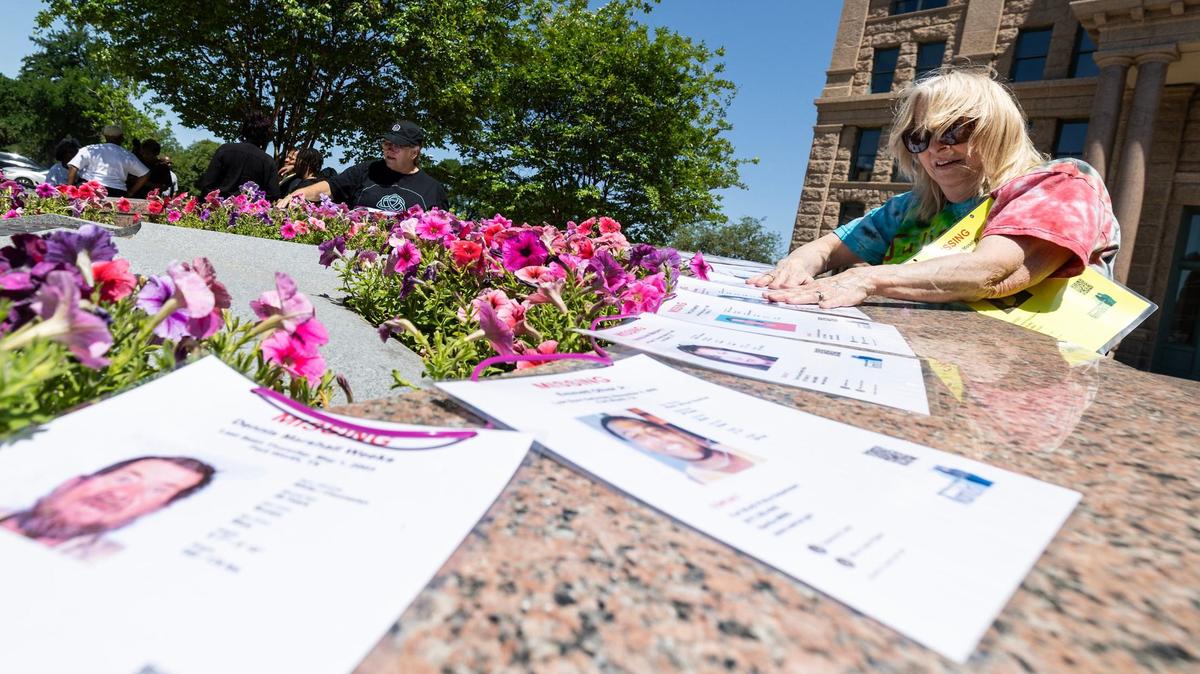 Janet Mosley places pictures of victims involved in a cold case during the cold case rally in front of the Tarrant County Courthouse in downtown Fort Worth on Saturday, April 13, 2024.