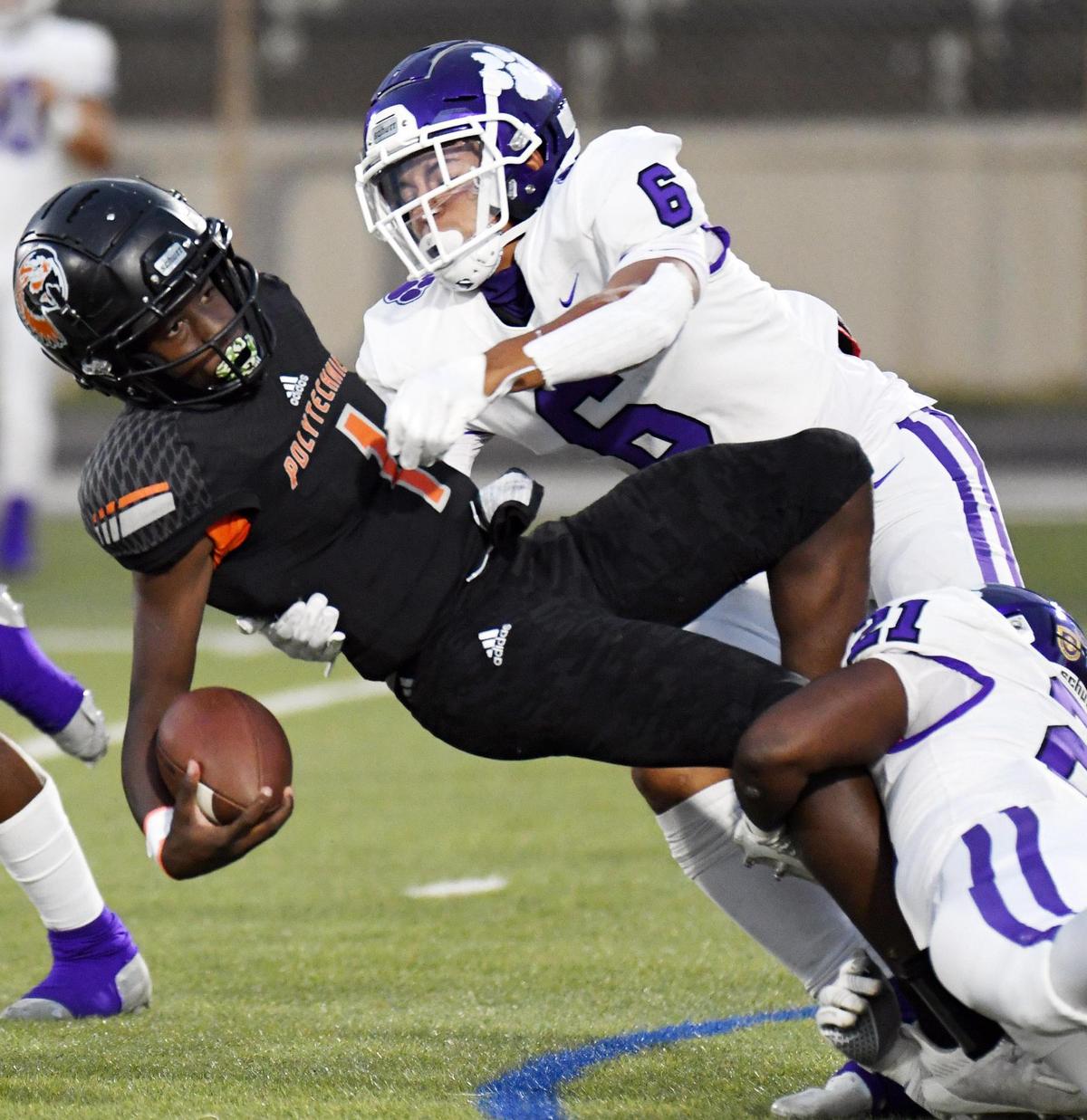 Polytechnic quarterback Quincy Carter, left is brought down by Paschal’s Austin Cunningham and Tommy Bell after a short gain in the first quarter of their football game Thursday, October 8, 2020 at Clark Stadium in Fort Worth, Texas. Special/Bob Haynes