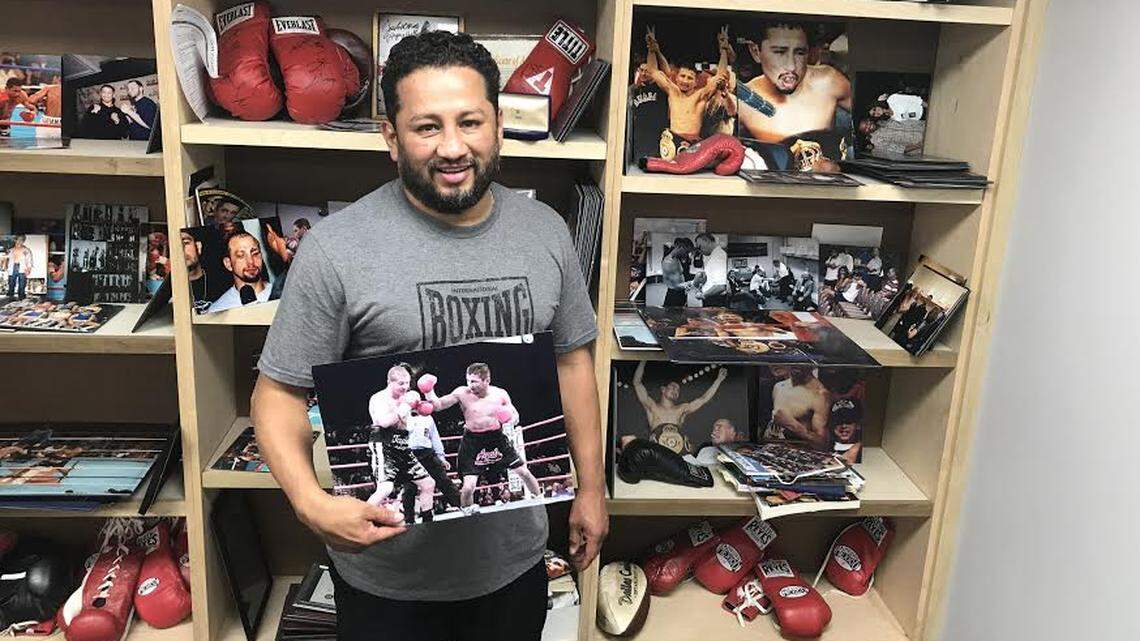 At his boxing gym in Fort Worth, Paulie Ayala holds up a photo from his win against Johnny Tapia in June of 1999 for the bantamweight championship belt.