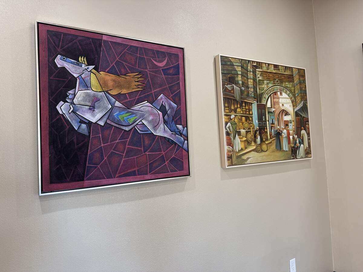 A geometric horse artwork that symbolizes good luck in Indian and Hindu traditions and next to it a painting of an ancient marketplace at the Art Algebra studio in Colleyville.