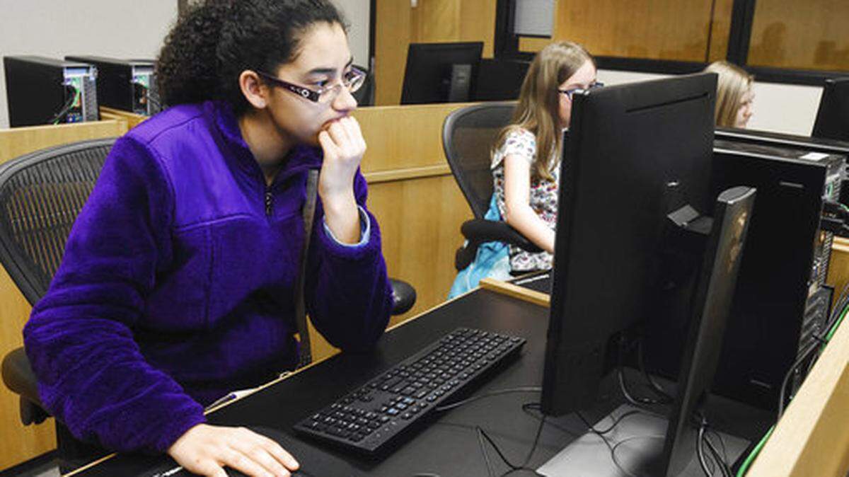 In this Feb. 15, 2017 photo, Serena Perez-Takaya works on making a phone app simulation while attending Girls Who Code, a program Fort Wayne, Ind. Girls Who Code is a national nonprofit dedicated to closing the gender gap in technology. Women also experience a wage gap compared to male counterparts.(Michelle Davies/The Journal-Gazette via AP)