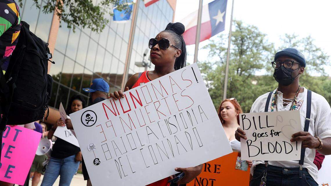 Robert Miller's wife, Shanelle Jenkins, holds a sign during a rally outside of a Tarrant County Court of Commissioners meeting. The sign, which is in Spanish, highlights that 39 people had died in the Tarrant County Jail from 2019 to May 10, 2022.