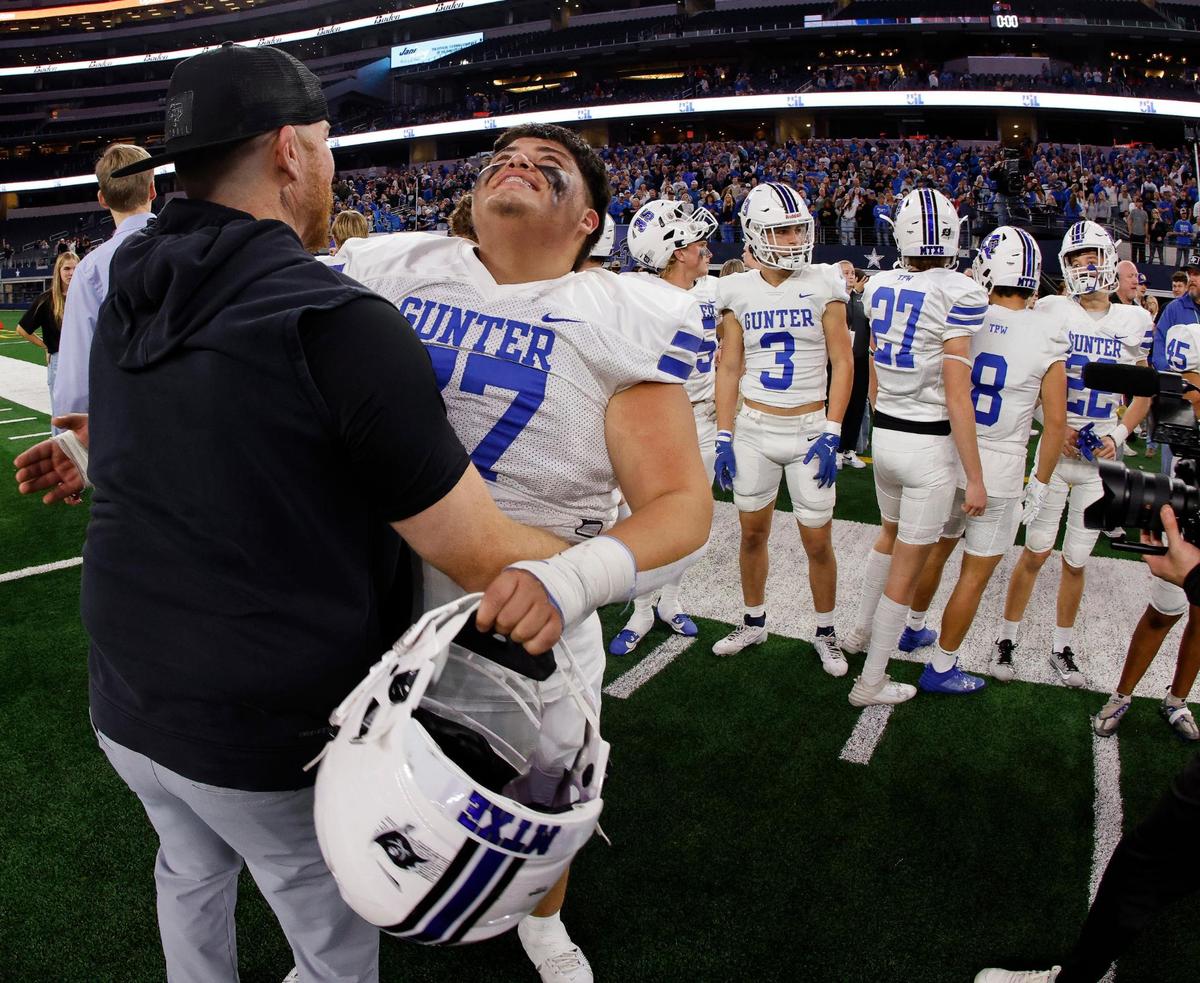 Gunter lineman Julian Valenzuela can’t contain his excitement as assistant coach Casey Frost gives him a hug after winning the UIL Conference 3A Division 2 state championship football game at AT&T Stadium in Arlington, Texas, Thursday, Dec. 14, 2023.
