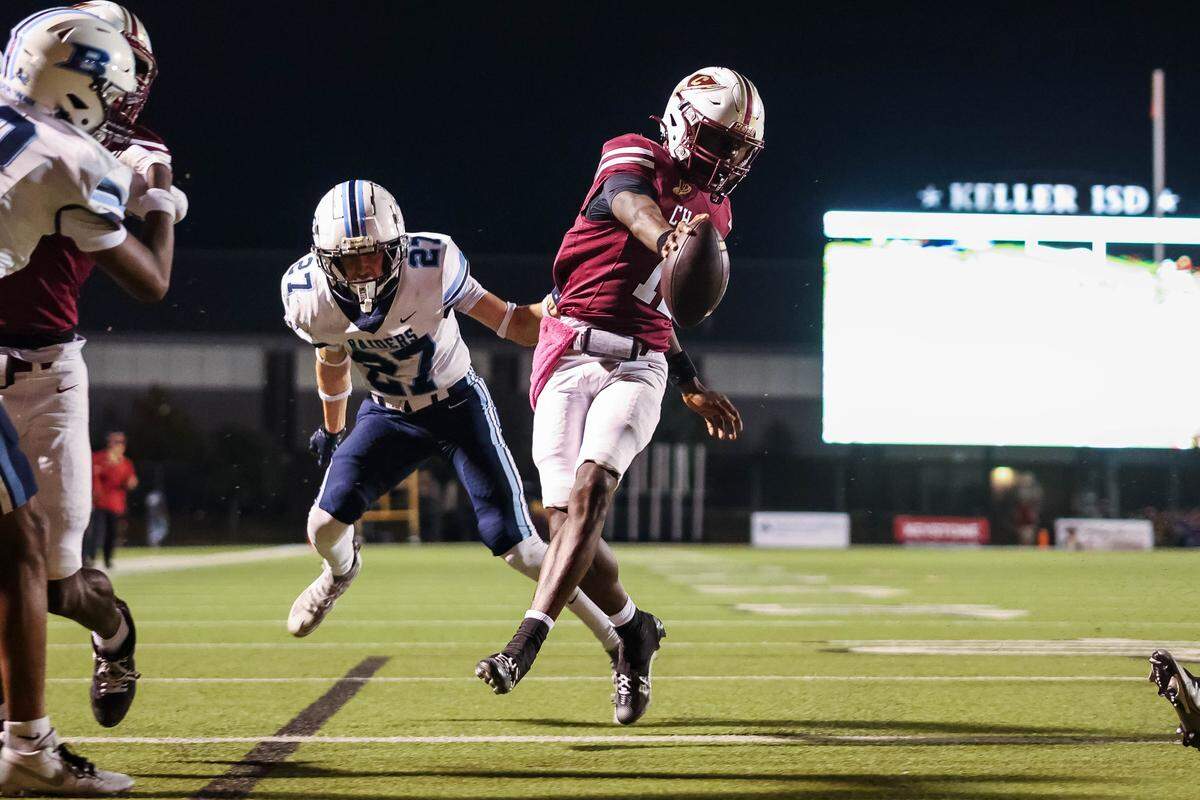 Keller Central quarterback Isaiah Taylor reaches toward the goal line for a touchdown during a district game between Keller Central and L.D. Bell at Keller ISD Stadium in Keller, Texas on October 16, 2025.