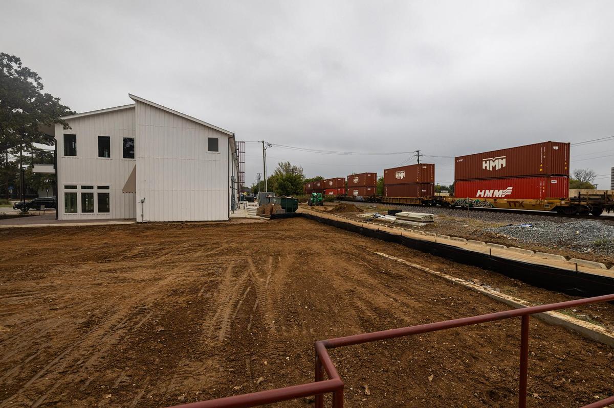 A cargo train rumbles past one of Urban Union’s new mixed-used buildings.