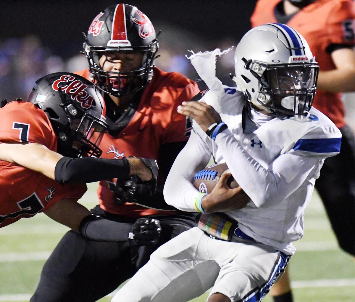 Burleson’s Cayden Carmill, left and Parker Hay try to stop Centenial quarterback Phillip Hamilton as he runs in for the touchdown to give the Spartans a 21-6 lead in the second quarter during Friday’s, August 26, 2022 football game at Elk Stadium in Burleson, Texas. Special/Bob Haynes