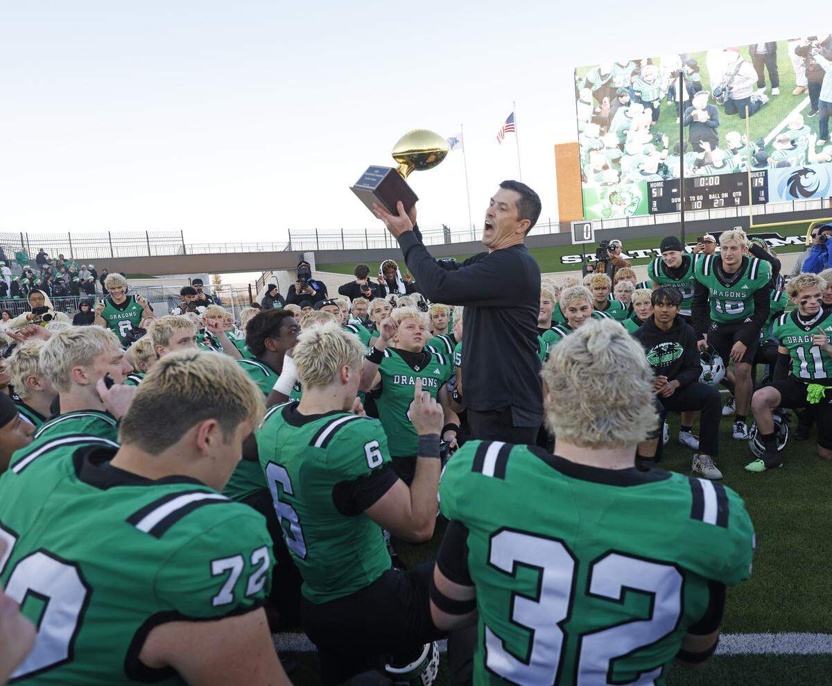 Southlake Carroll head coach Riley Dodge presents the trophy to the Dragons after defeating Denton Guyer in a UIL Class 6A Division II Quarterfinal on Saturday Dec. 06, 2025 at Crowley ISD Multi-Purpose Stadium in Fort Worth, Texas.