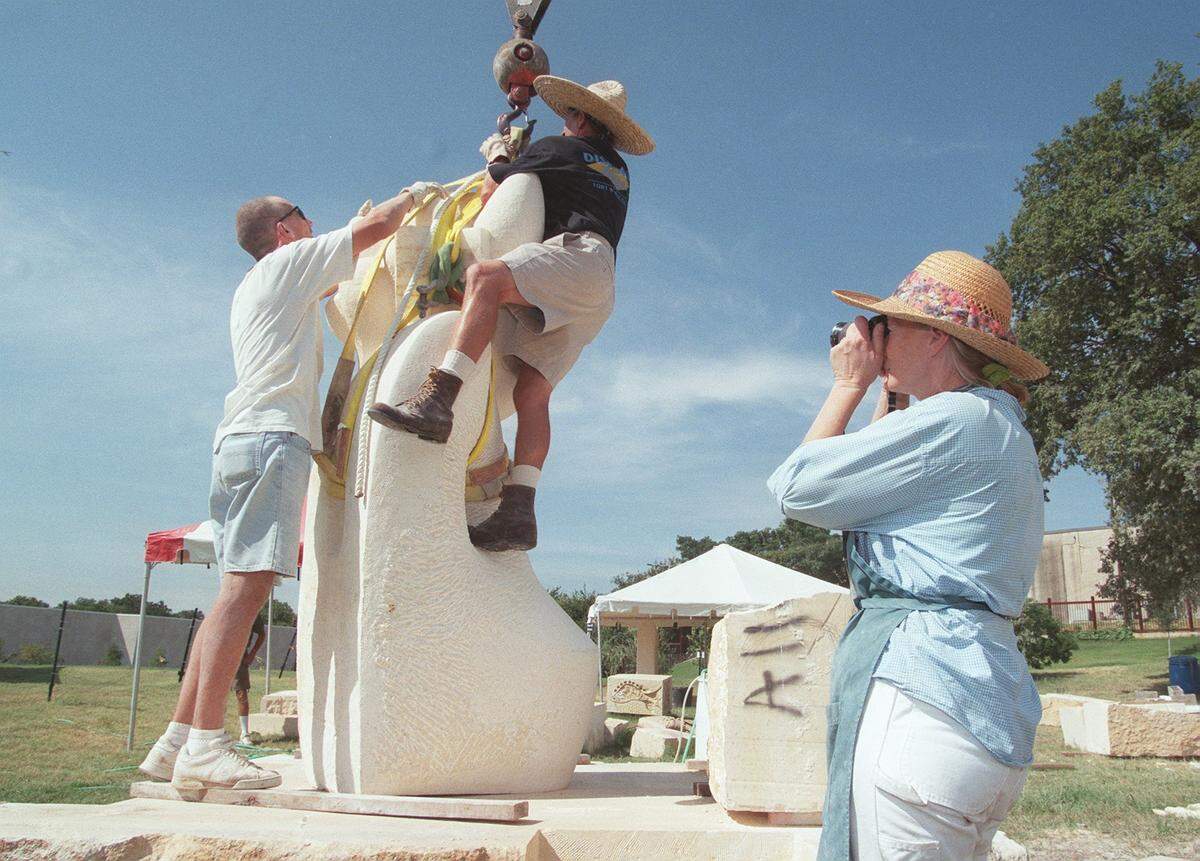 Aug. 27, 1999: Alice Bateman takes a picture of the vertical piece of her sculpture 'Natura' at the Fort Worth Botanic Garden after was lifted to an upright position, as Cameron Schoepp and Tom Vanderzyl undo the lifting straps.
