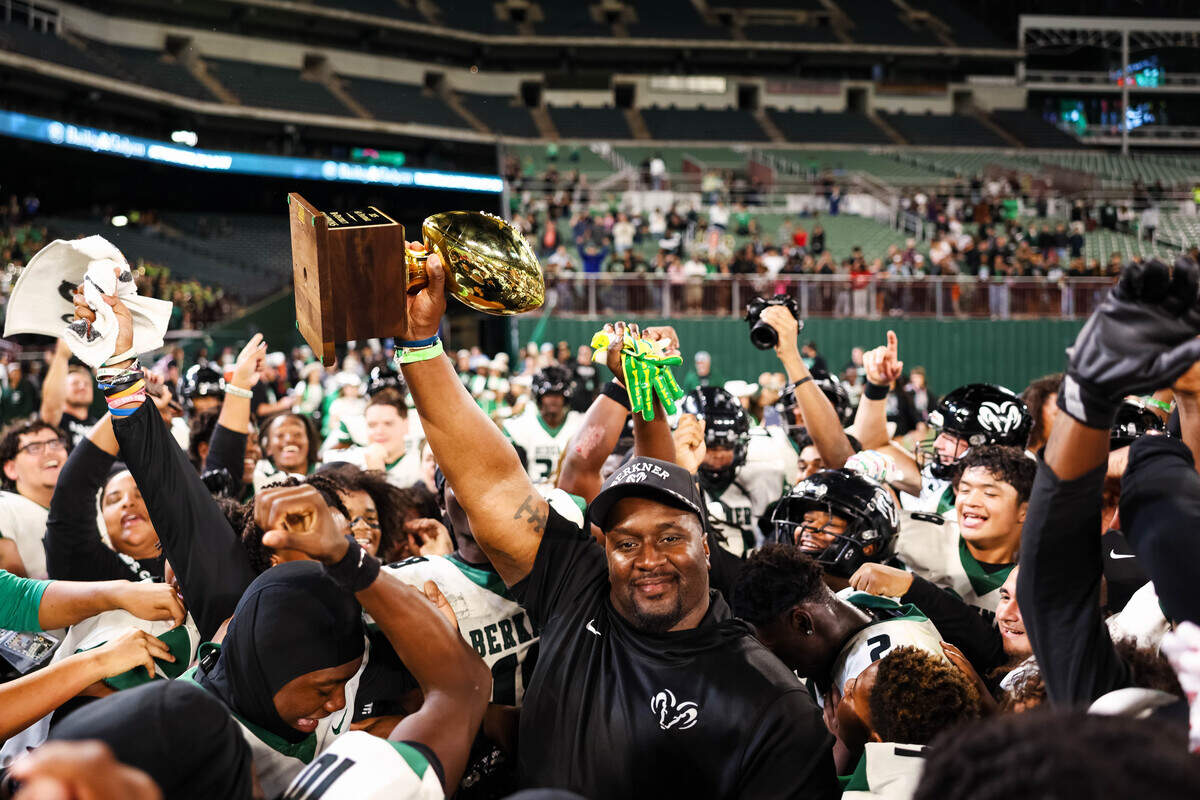 Berkner head coach Trey Bryant lifts the trophy in the air while his players celebrate around him after a 30-28 win over Arlington Bowie in a bi-district playoff game at Choctaw Stadium in Arlington, Texas on Nov. 14, 2025.