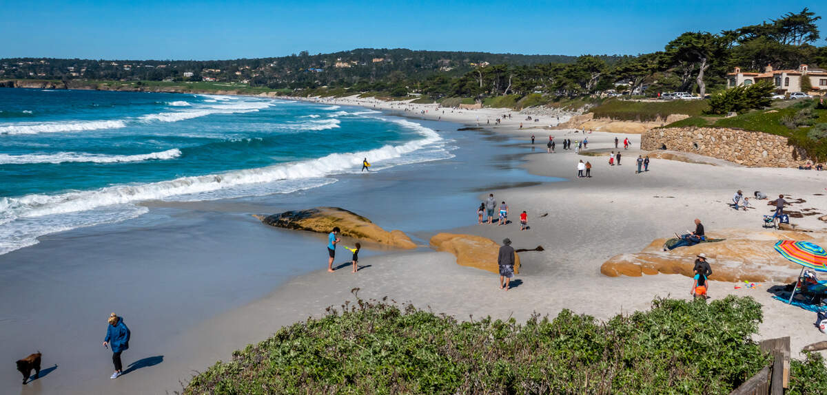 Monterey, CA, residents and tourists visits the city’s Carmel Beach.
