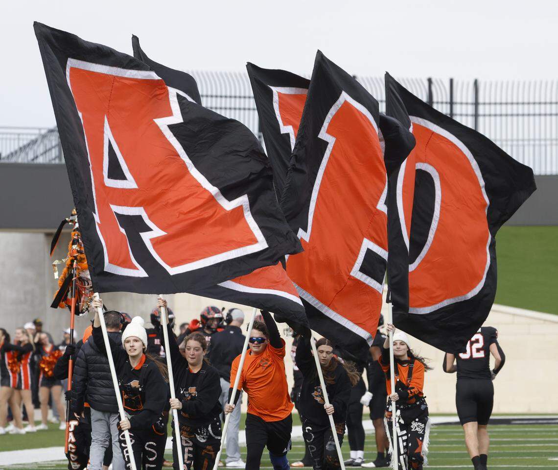 The Aledo flag runners run the field after a score against Fort Worth Arlington Heights during the first half of a UIL Class 5A Division I Regional on Friday Nov. 28, 2025 at Crowley ISD Multi-Purpose Stadium in Fort Worth, Texas.