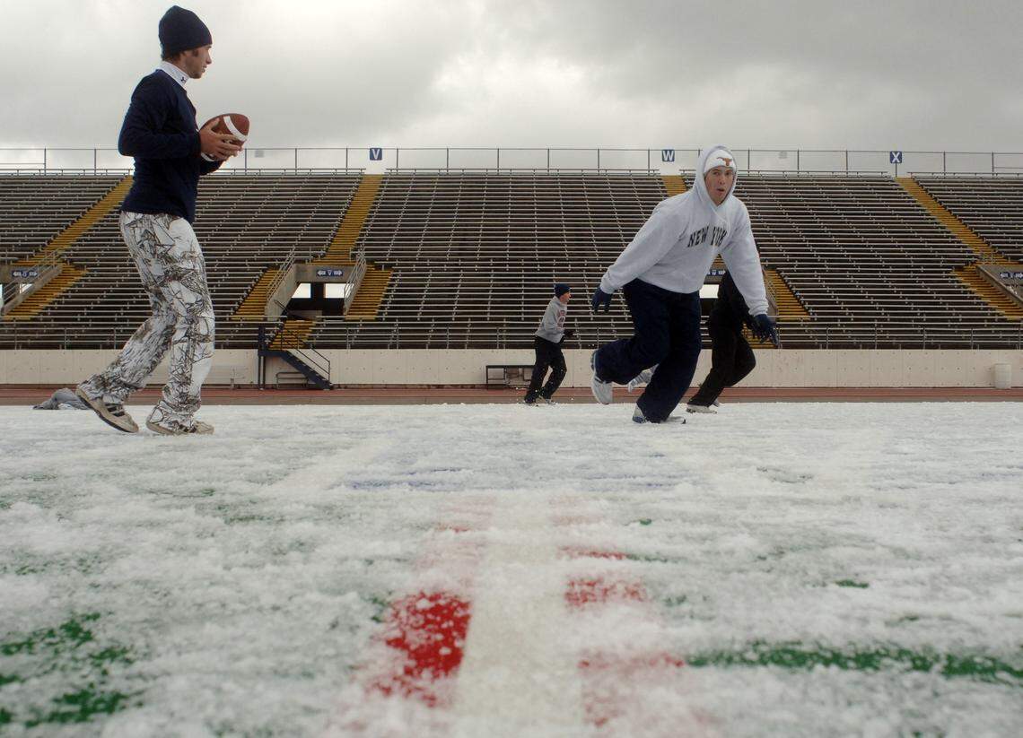 UT Arlington marketing major Zach Reeves, left, of Mansfield quarterbacks as freshman and South Africa native Bryce Easton goes takes off downfield during a pickup football game on the ice-covered Maverick Stadium field on Nov. 30, 2006.