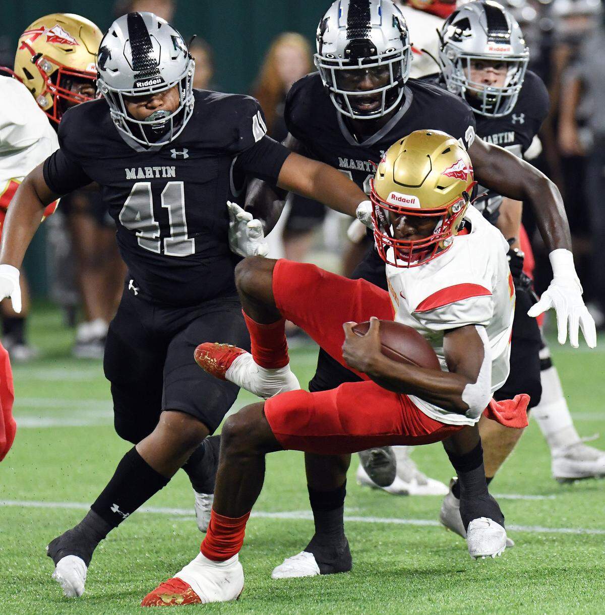 Arlington Martin’s Jaiden Christopher, left and Johnathon Okate trip up South Grand Prairie quarterback Michael Stallworth for loss in the second quarter of their District 8-6A football game at Choctaw Stadium in Arlington, Texas. Special/Bob Haynes