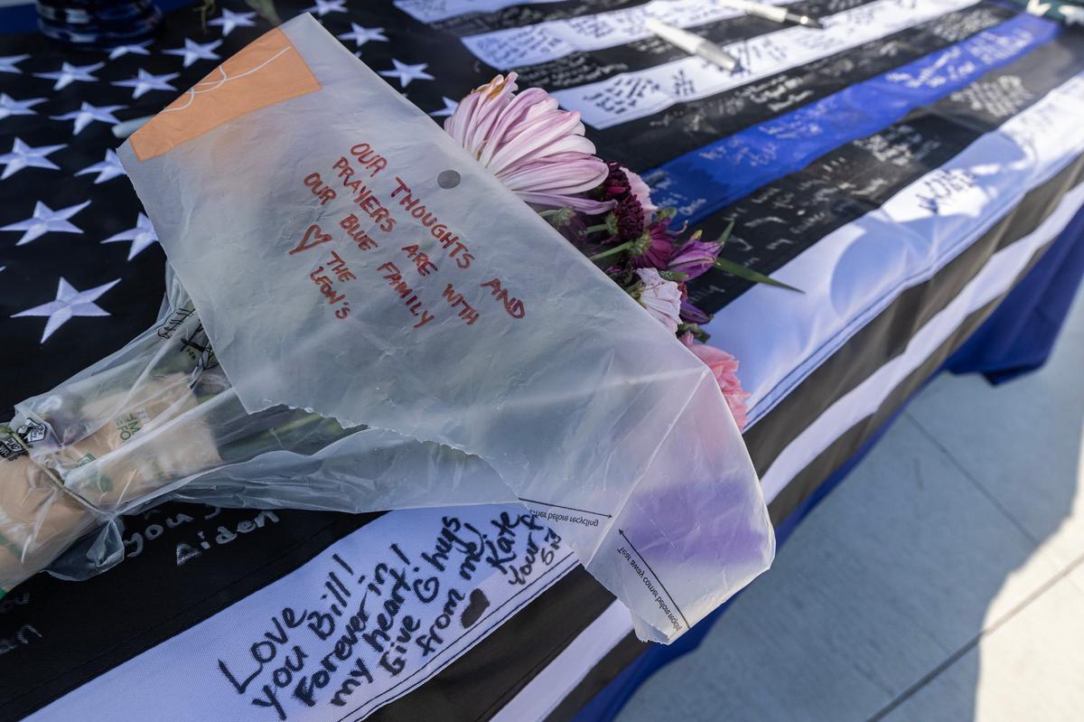 Flowers and handwritten notes are left on a memorial in memory of the late Fort Worth Police Department Sgt. Billy Randolph at Fort Worth PD South Division headquarters on Tuesday. Sgt. Randolph was struck by a vehicle while working a crash scene on the exit ramp of I-35W near Sycamore School Road on Monday morning.
