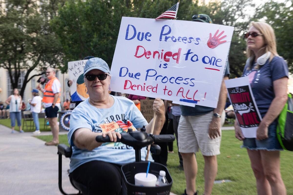 Tarrant County resident Kathy Meissner rides through the crowd with her sign during the ‘Good Trouble’ rally in Burk Burnett Park in downtown Fort Worth on Thursday, July 17, 2025.