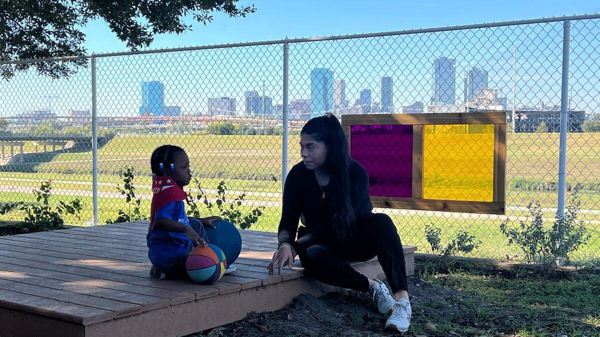 Assistant teacher Sarahi Martinez plays with a 2-year-old student at the toddler playground at the Child Care Studio at Riverside on Tuesday, Nov. 12, 2024.
