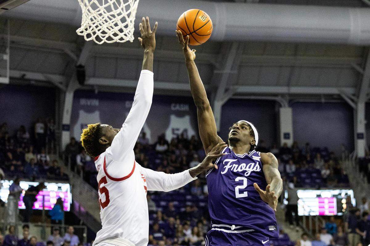 TCU forward Emanuel Miller (2) goes up for a layup over Cincinnati center Aziz Bandaogo (55) on Saturday.