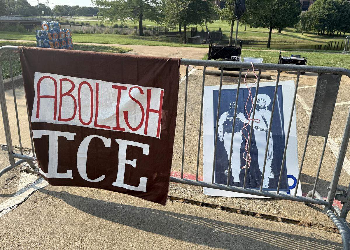 Protest signs hang from metal barrier outside of an ICE job fair held at the Esports Stadium Arlington on Wednesday, Aug. 27, 2025.