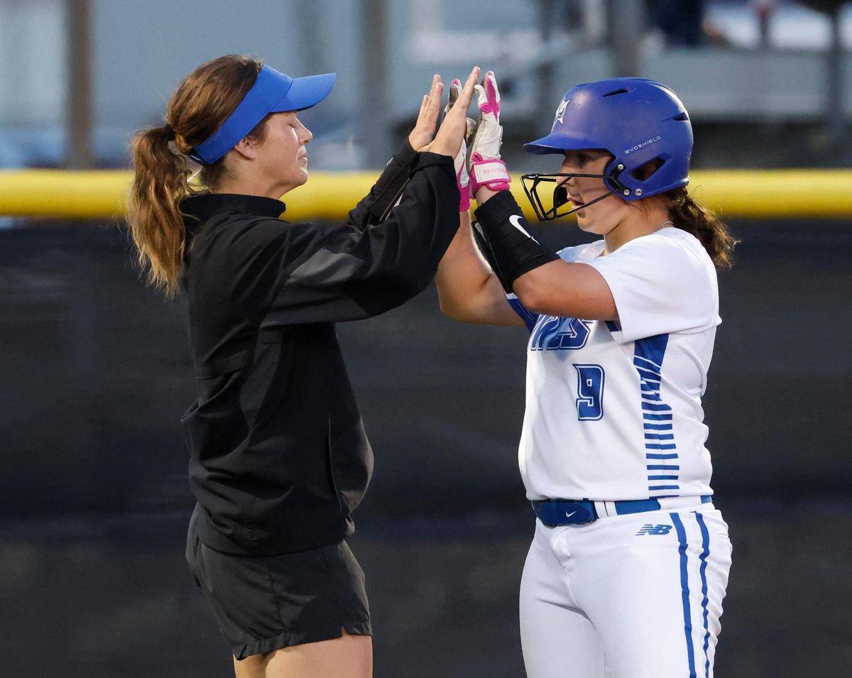 Joshua head coach Ashley Benson congratulates catcher Taylor Proffitt (9) after her triple drove in three runs during a UIL 5A D2 bi-district softball playoff game at Eagle Softball Field in Crowley, Texas, Thursday, Apr. 24, 2025.