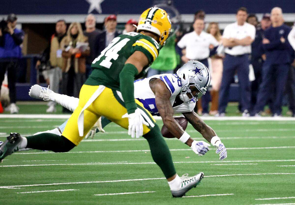 Dallas Cowboys wide receiver CeeDee Lamb misses a throw while being covered by Green Bay Packers safety Jonathan Owens during the NFC wild-card playoff game on Sunday, January 14, 2024, at AT&T Stadium in Arlington.