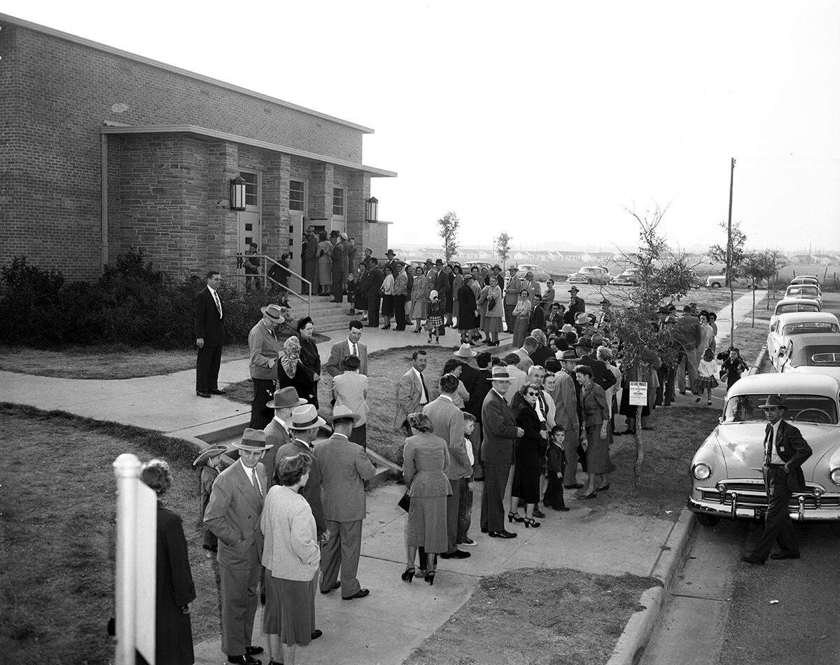 Nov. 4, 1952: At noon voters at Precinct 117 had to go to the schoolyard to make room for children to eat their lunches in the auditorium. They leaned against outside walls to mark ballots.