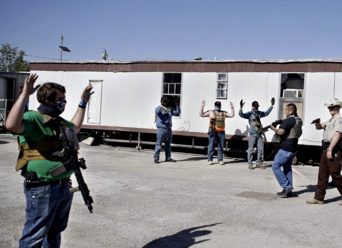 Deputies of the Ector County Sheriff’s Office advance on protesters who gathered outside Big Daddy Zane’s bar Monday, May 4, 2020, in Odessa, Texas. Big Daddy Zane’s opened Monday afternoon despite the Texas governor’s orders prohibiting its operation until later in May. Armed protesters arrived to support the bar owner’s decision, leading to arrest of eight individuals including the bar owner.