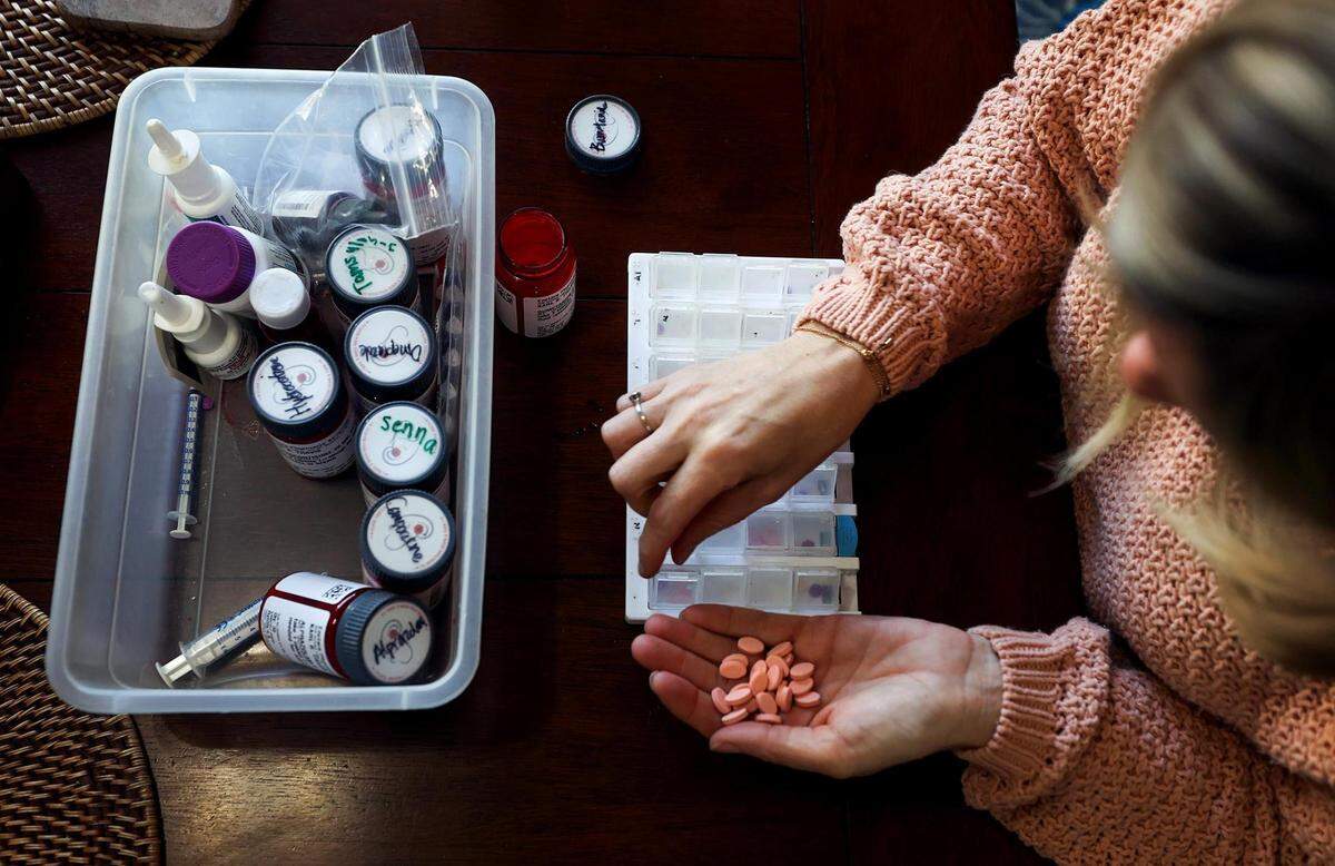 Jaci Travis organizes her husband Karl Travis’ medication.