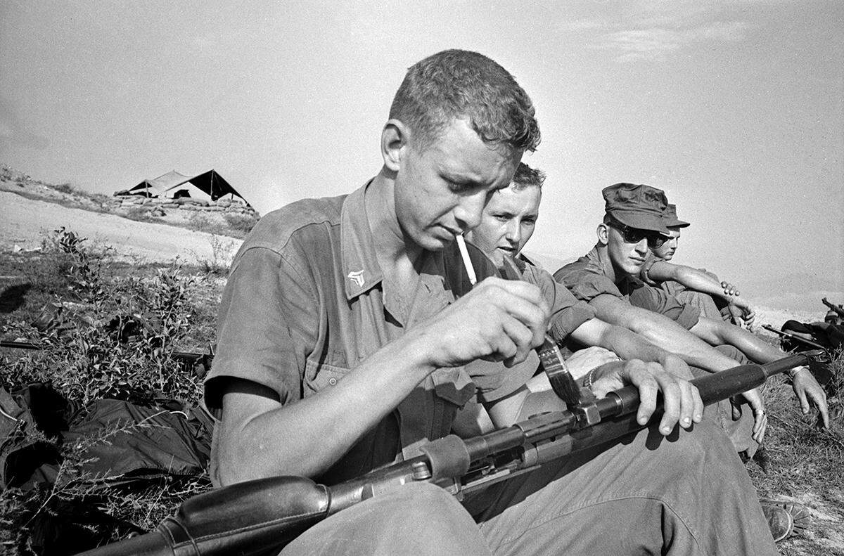 U.S. Marine Corps Cpl. Joe Beaver Jr. of Arlington is seen cleaning his rifle before breaking camp for a mission during the Vietnam War.