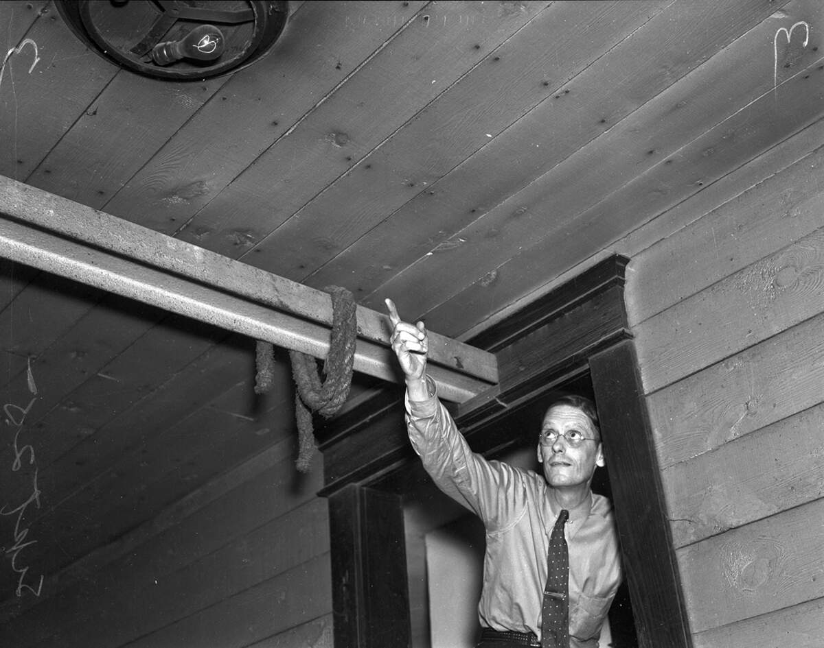 In this photo taken Sept. 25, 1936, Harry Gould, manager of Palace Theater on 7th Street near Main Street in downtown, points to an electric light bulb that has burned continuously since 1908 above a backstage door.