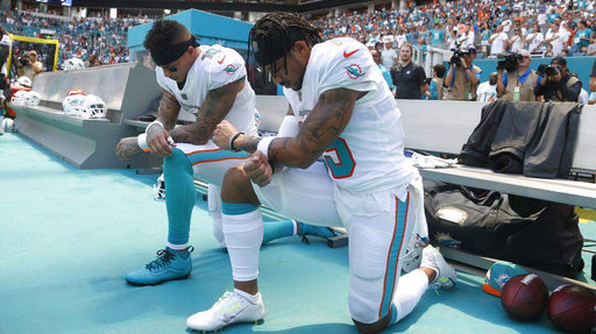 Miami Dolphins wide receiver Kenny Stills (10) and Miami Dolphins wide receiver Albert Wilson (15) kneel during the national anthem before an NFL football game against the Tennessee Titans, Sunday, Sept. 9, 2018, in Miami Gardens, Fla.