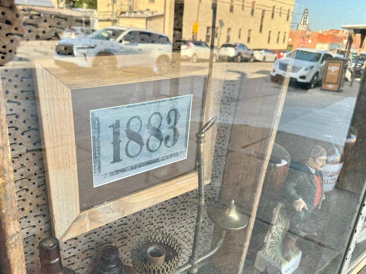A logo from the TV show “1883” remains in the window at The Brand Room steakhouse and bar in Fort Worth.s