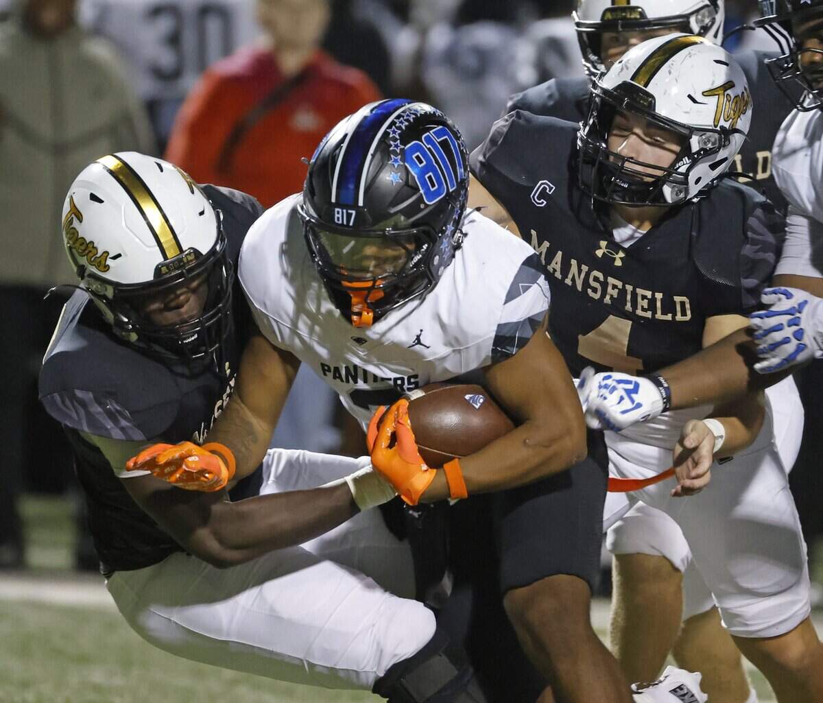 North Crowley running back G’Yrell Smith (3) is brough down by Mansfield linebackers Andrew McKinney (33) and  Kit Carpenter (4) during the first half of a UIL football game between North Crowley and Mansfield at Vernon Newsom Stadium in Mansfield, Texas, Thursday, October, 30, 2025.