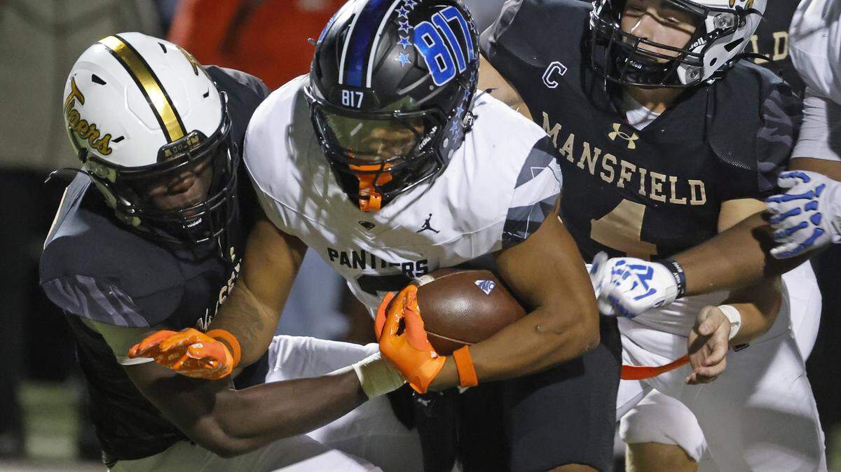 North Crowley running back G’Yrell Smith (3) is brought down by Mansfield linebackers Andrew McKinney (33) and Kit Carpenter (4) during the first half of a UIL football game between North Crowley and Mansfield at Vernon Newsom Stadium in Mansfield, Texas, Thursday, October 30, 2025.