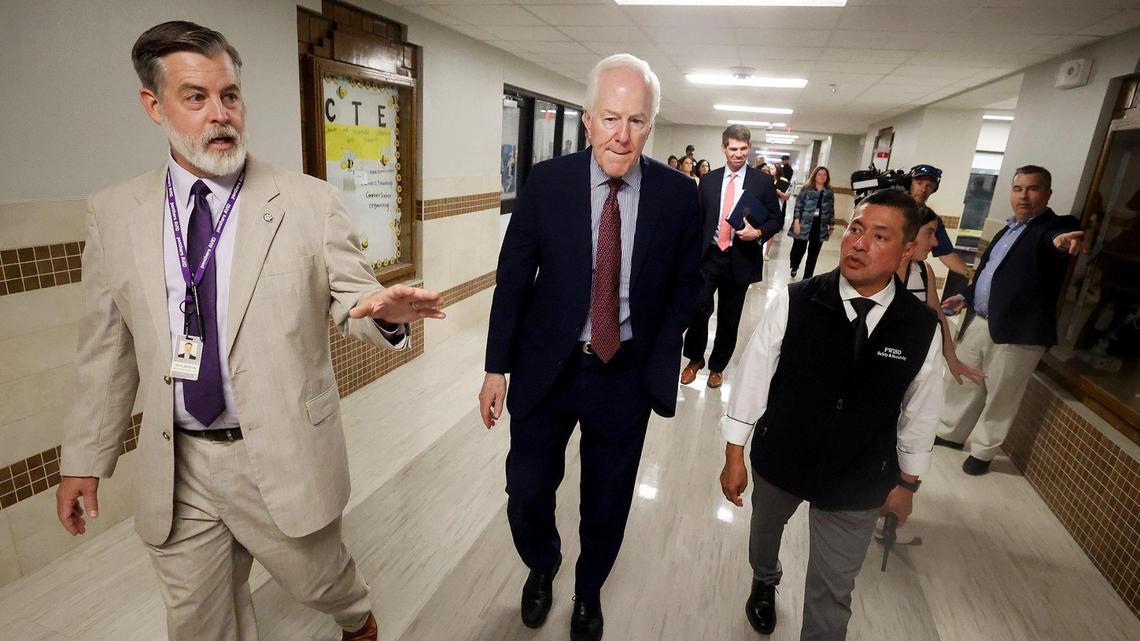Troy Langston, principal of Paschal High School, left, and Daniel Garcia, security director of the Fort Worth school district, right, give U.S. Sen. John Cornyn a tour Monday of the security measures put in place at Paschal High School. The Bipartisan Safer Communities Act, which passed in 2022, provided grant money to the Fort Worth school district for its school safety program.
