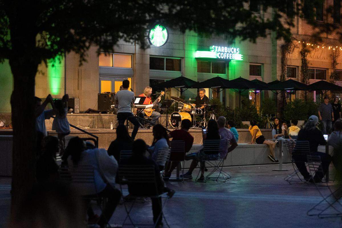 People listen to a band playing in Sundance Square on Saturday, May 7, 2022, in downtown Fort Worth.