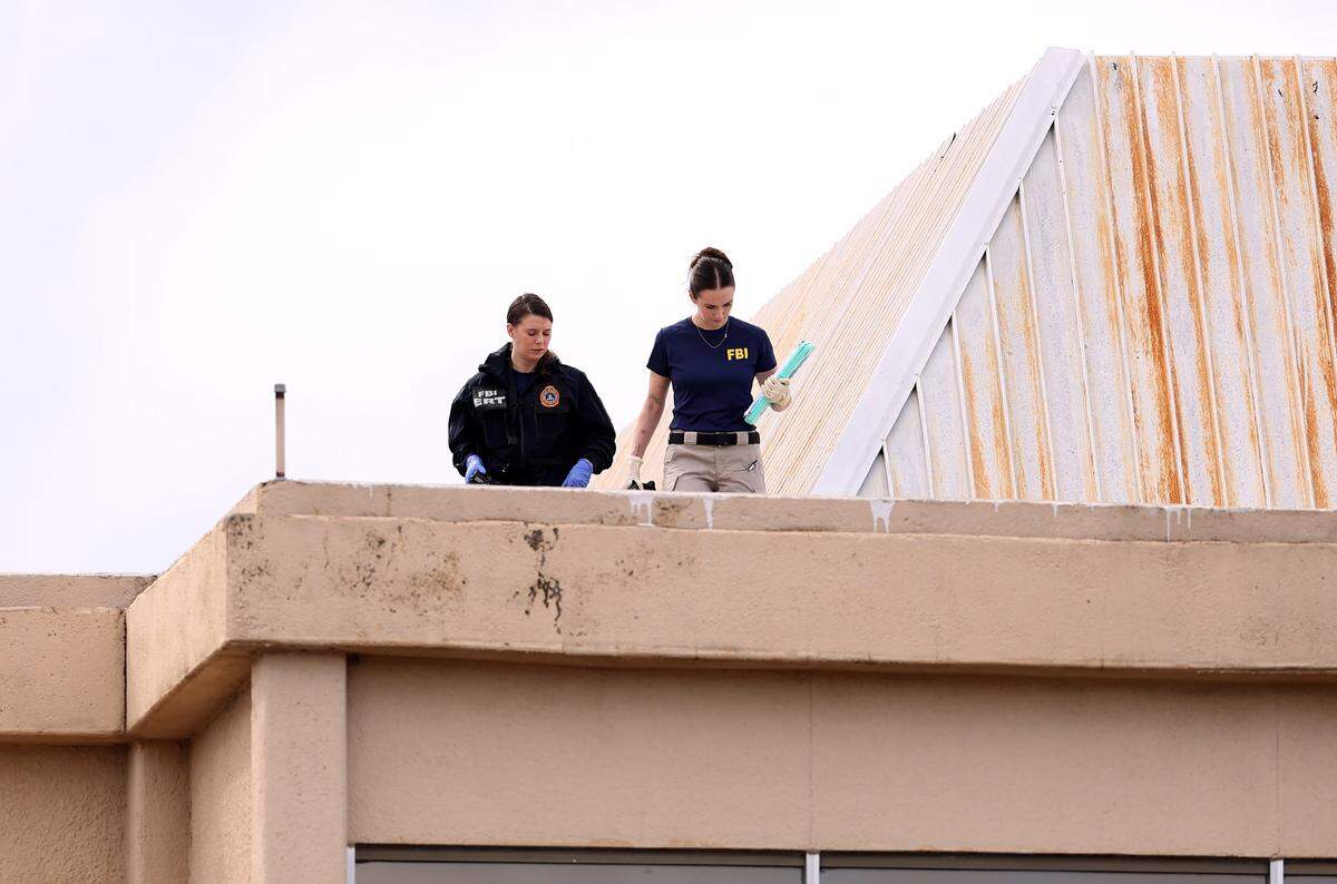 FBI officers investigate the roof of a building near the scene where a shooting at an Immigration and Customs Enforcement facility occurred in Dallas on Wednesday, Sept. 24, 2025. One victim was killed and two were critically injured, officials said. The victims were ICE detainees. The shooter is dead.